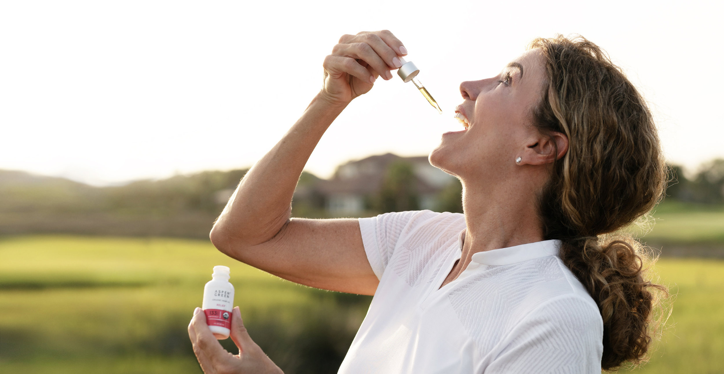 Woman taking CBD oil on golf course
