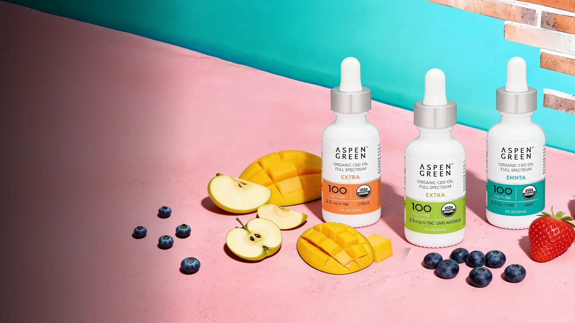 Three bottles of Aspen Green Extra Strength CBD oil with fruit accents, highlighting premium organic full spectrum CBD tinctures.