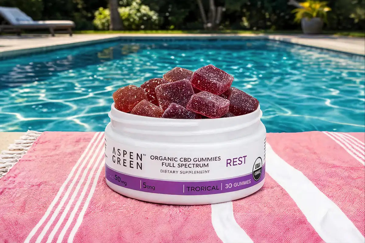 Jar of Aspen Green CBD Rest gummies on a poolside towel