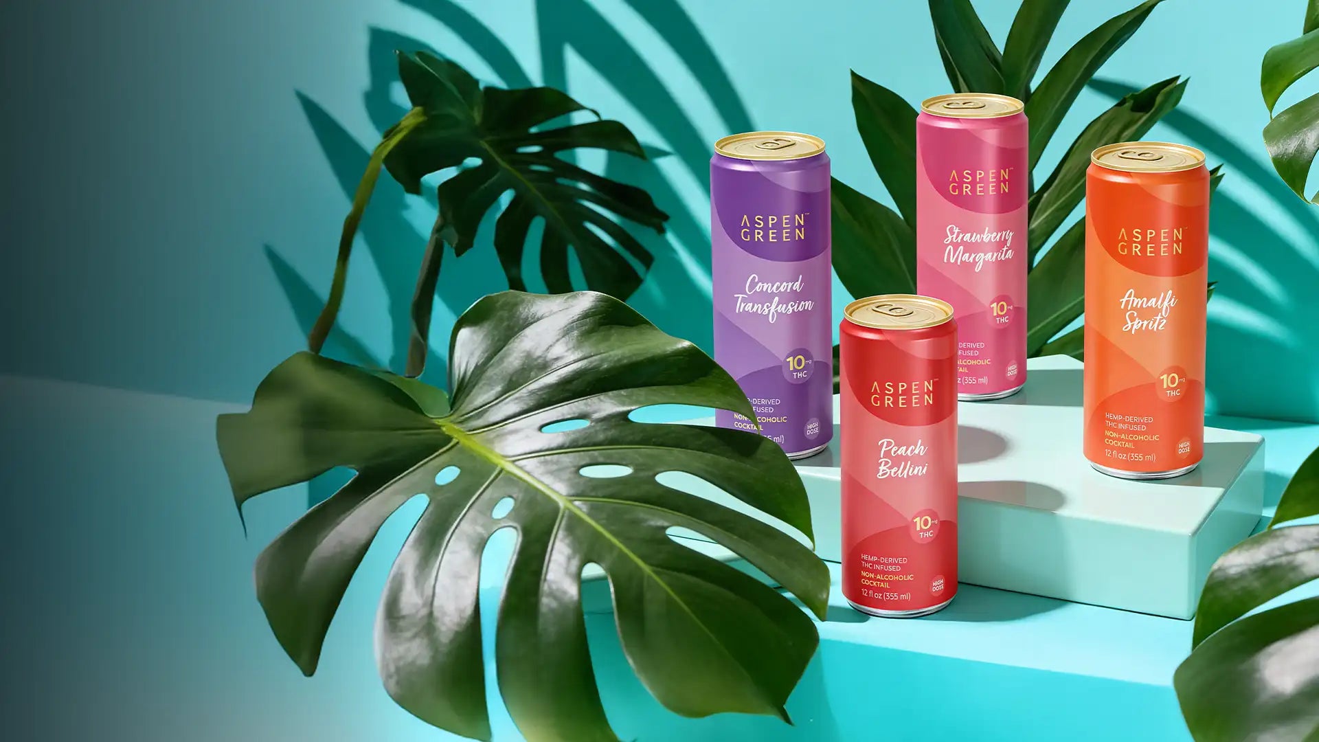 Colorful Aspen Green THC beverages on a blue surface with green leaves