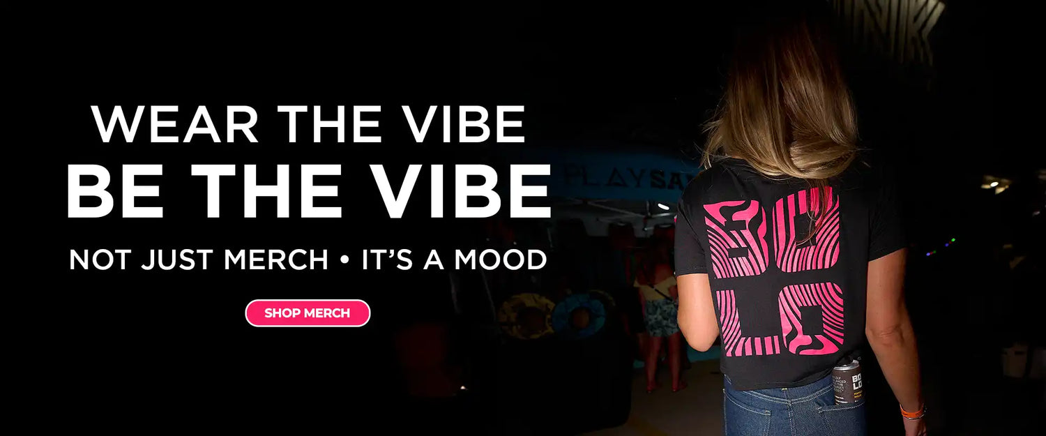 Person wearing a black BOLO t-shirt with a pink design, standing in a dimly lit setting.