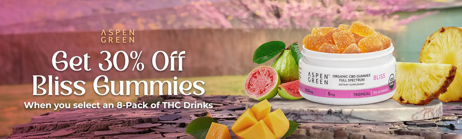 Promotional banner for Aspen Green Bliss Gummies with a jar of gummies, fruits, and a pineapple on a wooden surface.