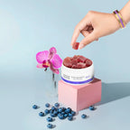 Woman’s hand picking Aspen Green CBD Rest Gummies from an open container