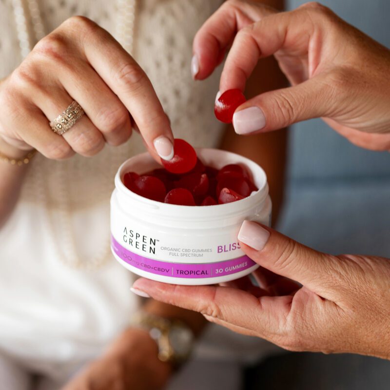 People grabbing Aspen Green CBD bliss gummy from container