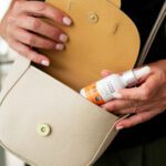 Woman putting Aspen Green Extra Citrus CBD Oil in purse