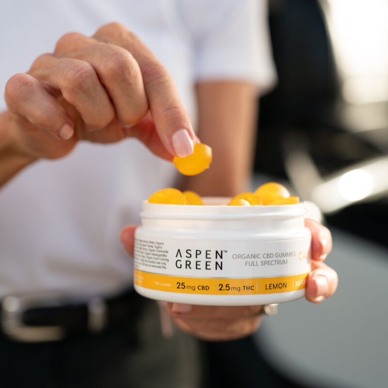 Woman taking Aspen Green CBD calm gummy from container
