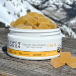 Aspen Green CBD Calm Gummies displayed on an outdoor table with a scenic mountain background