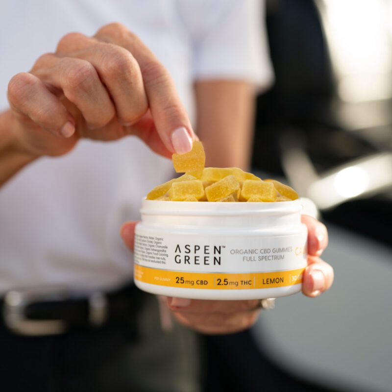 Woman taking Aspen Green CBD calm gummy from container