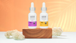 Aspen Green Bliss and Calm CBD Oils displayed on a wood pedestal